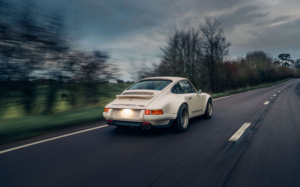 Cream Coupé, a Porsche 911 (964) reimagined by Theon Design: rear three-quarter view driving along a country road