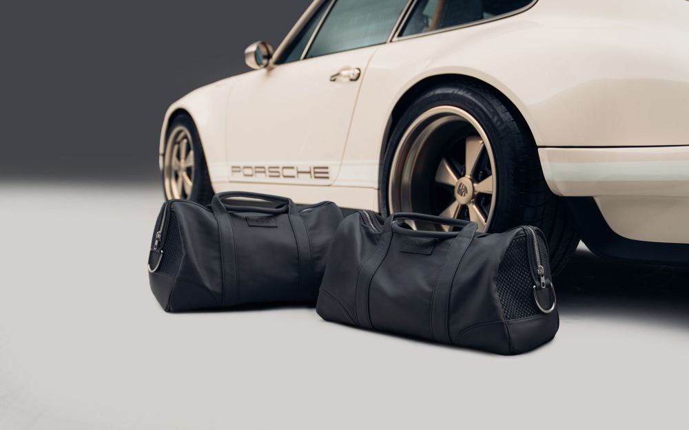 Cream Coupé, a Porsche 911 (964) reimagined by Theon Design: rear wheel and Porsche script beside two black leather holdalls