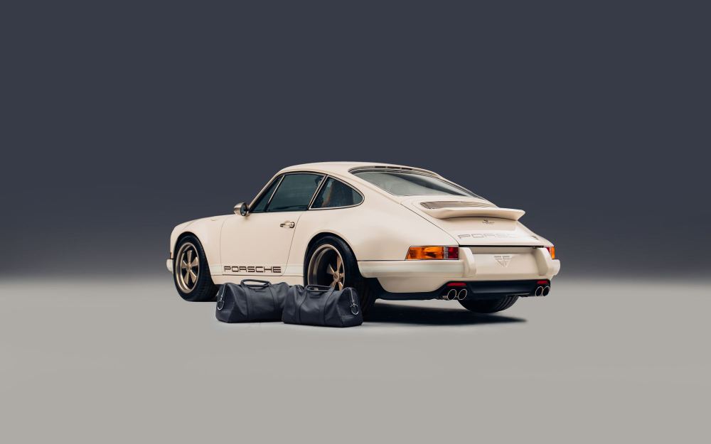 Cream Coupé, a Porsche 911 (964) reimagined by Theon Design: rear three-quarter view with matching luggage in the studio