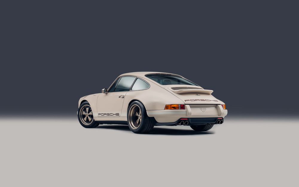 Cream Coupé, a Porsche 911 (964) reimagined by Theon Design: rear three-quarter view against a dark studio backdrop
