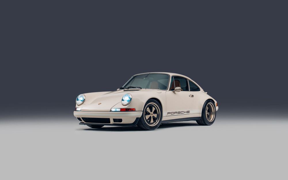 Cream Coupé, a Porsche 911 (964) reimagined by Theon Design: front three-quarter view with headlights on in the studio