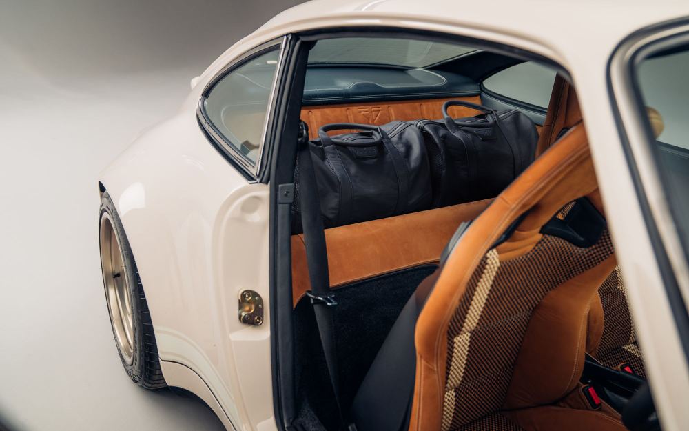 Cream Coupé, a Porsche 911 (964) reimagined by Theon Design: black leather holdall on the rear shelf, seen through the open door