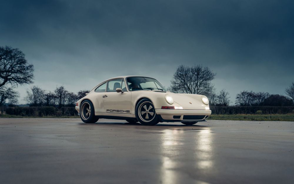 Cream Coupé, a Porsche 911 (964) reimagined by Theon Design: front three-quarter view on wet tarmac under a stormy sky