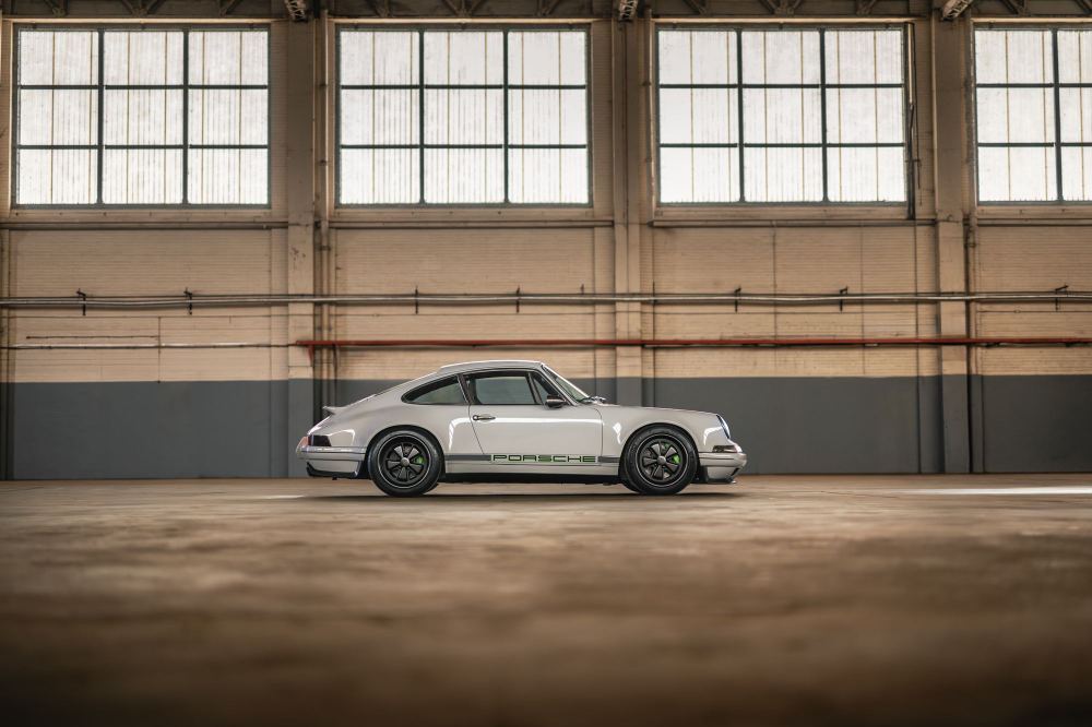 Silver Coupé, a Porsche 911 (964) reimagined by Theon Design: side profile beneath the hangar windows