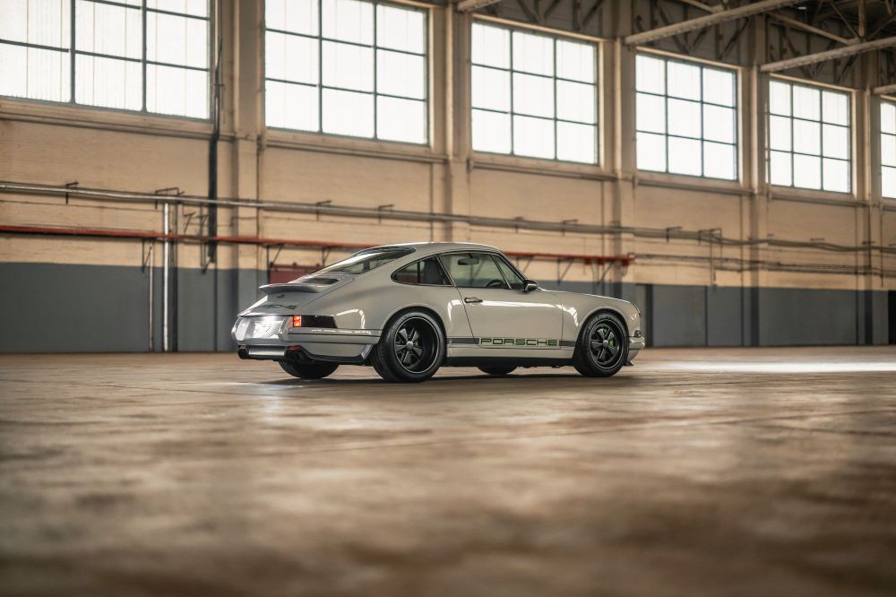 Silver Coupé, a Porsche 911 (964) reimagined by Theon Design: rear three-quarter view beneath the hangar windows