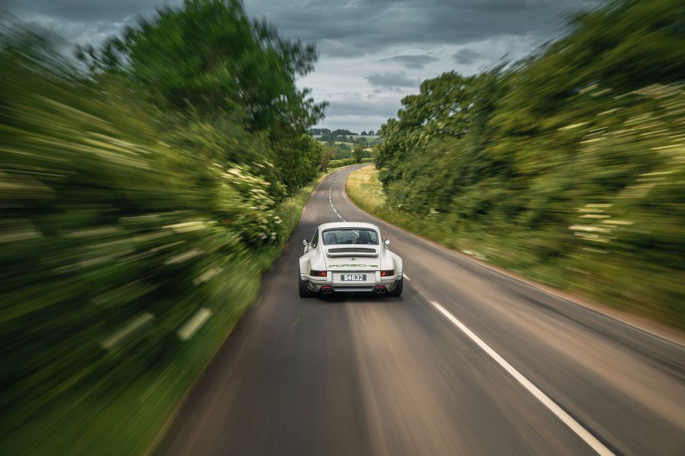 Silver Coupé, a Porsche 911 (964) reimagined by Theon Design: rear view driving along a country road