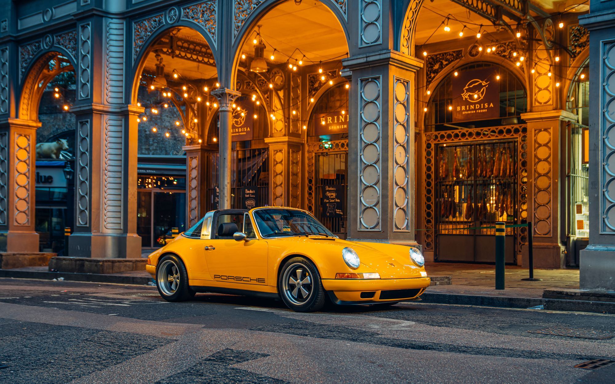 Yellow Targa, a Porsche 911 (964) reimagined by Theon Design under the lights of a London arcade